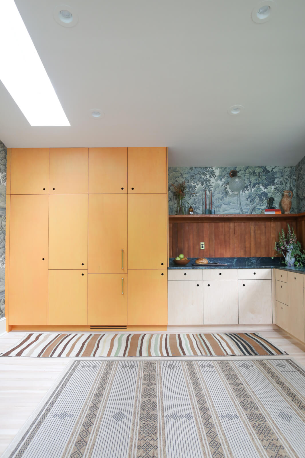 Floor to ceiling orange plywood cabinetry next to maple plywood lower cabinets in Northampton, MA